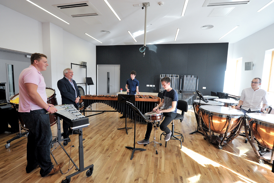 David Hocking stood with percussion students playing instruments in the RCM's percussion suite.